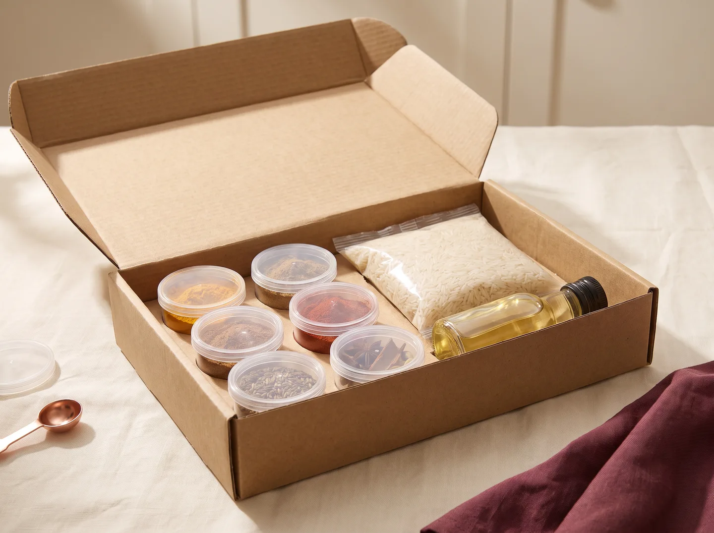 Concept photograph of an open kit box with spice pots, rice and oil